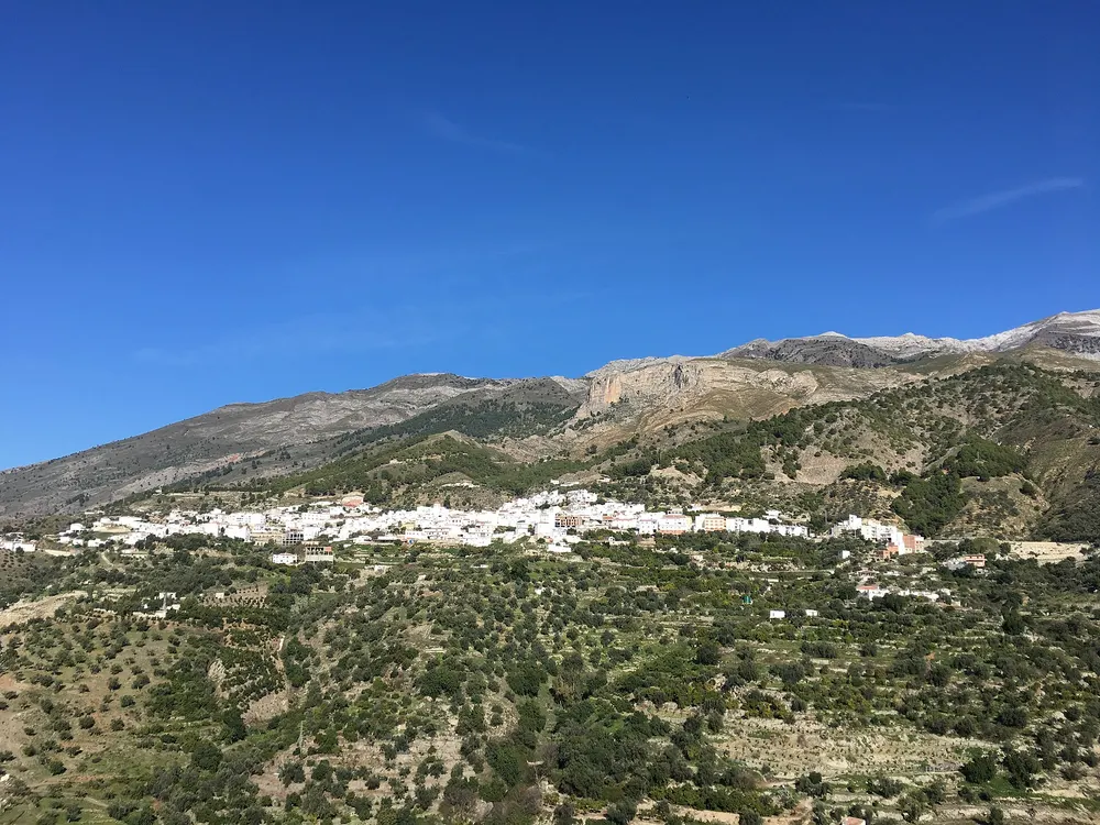 Het witte dorp Canillas de Aceituno tegen de bergen van de Axarquía, Málaga